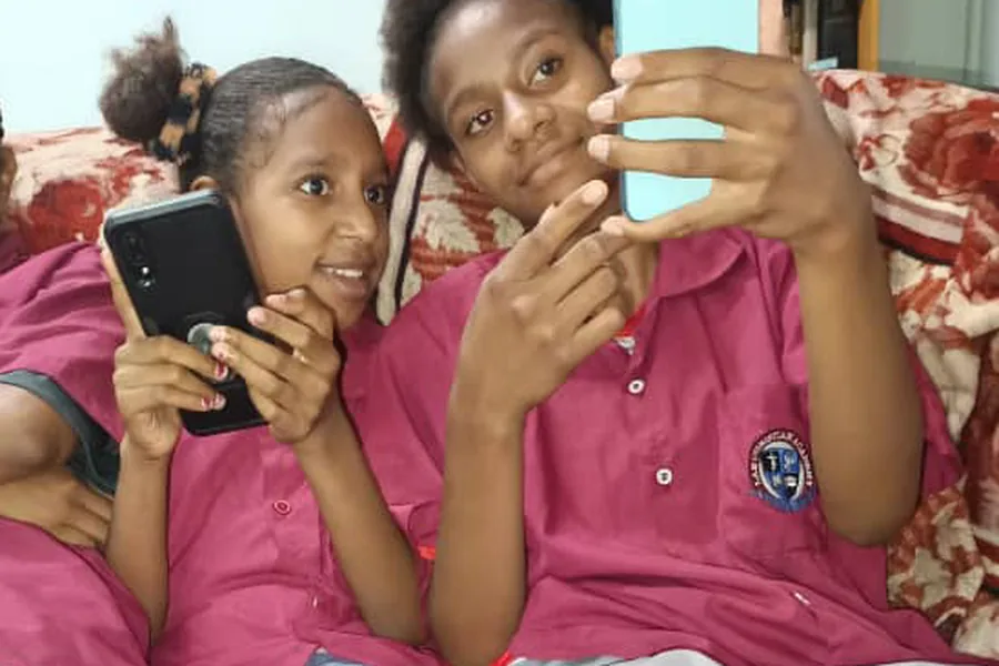 Two girls in Papua New Guinea with the EPHOD app on their phones